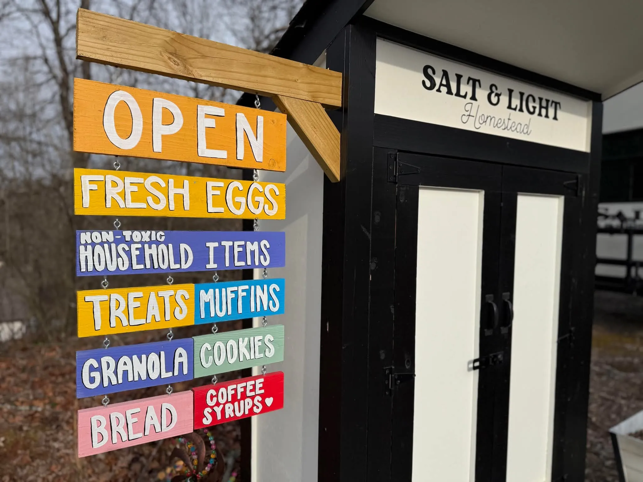 The Salt & Light Homestead sign listing fresh eggs, bread, muffins, cookies and other stand offerings