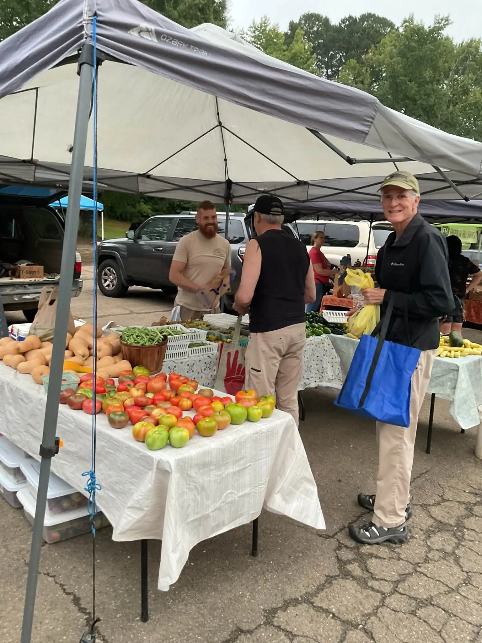 Vendor tents set up at the Jasper Farmers Market, with tables of heirloom tomatoes, squash and other produce for sale