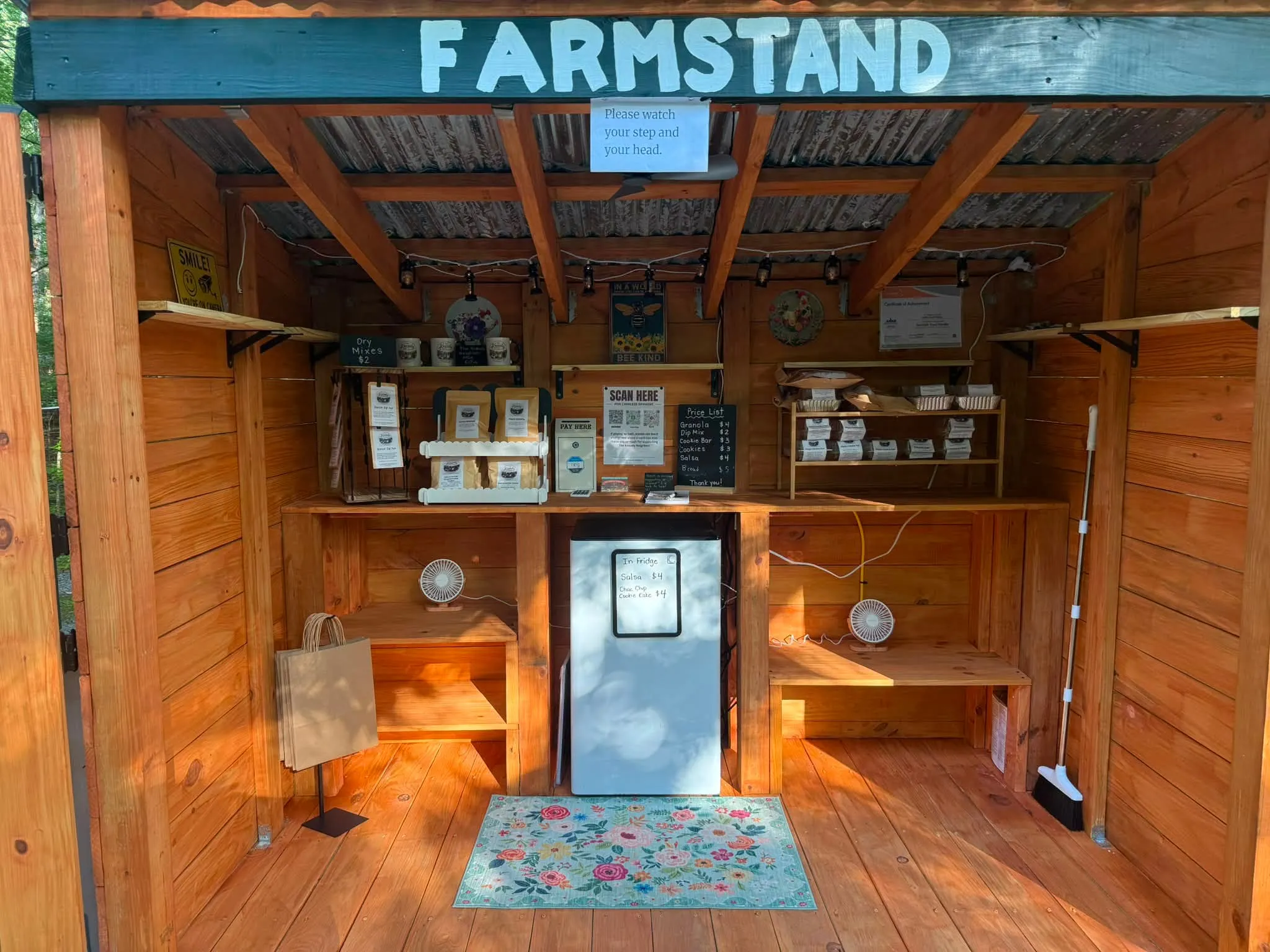 The Kneady Neighbor farmstand shed with a posted price list for bread, granola, cookies and salsa