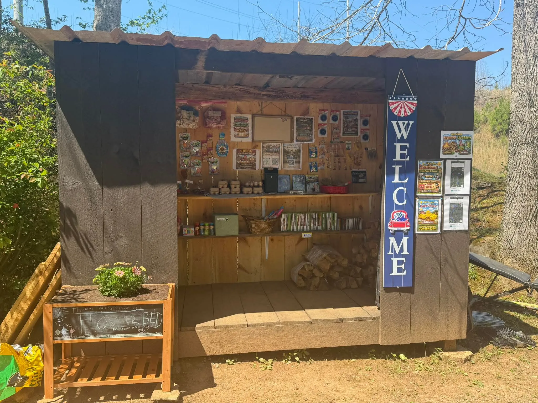The Antlers & Aprons roadside stand on Tails Creek Road, shelves stocked with eggs and homestead goods under a welcome sign