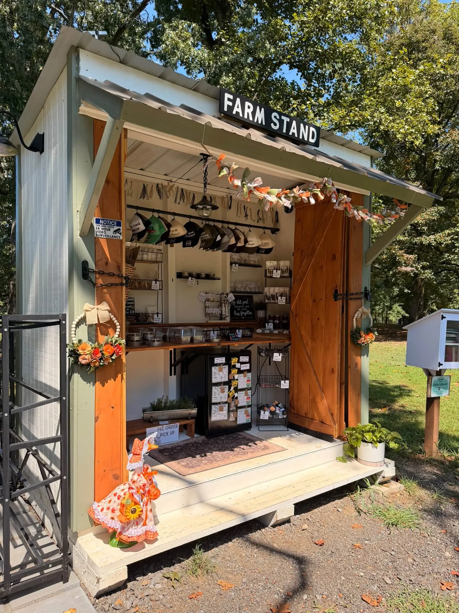 The Merchantile at Buckner Way, a farm stand shed hung with caps, wreaths and jarred goods